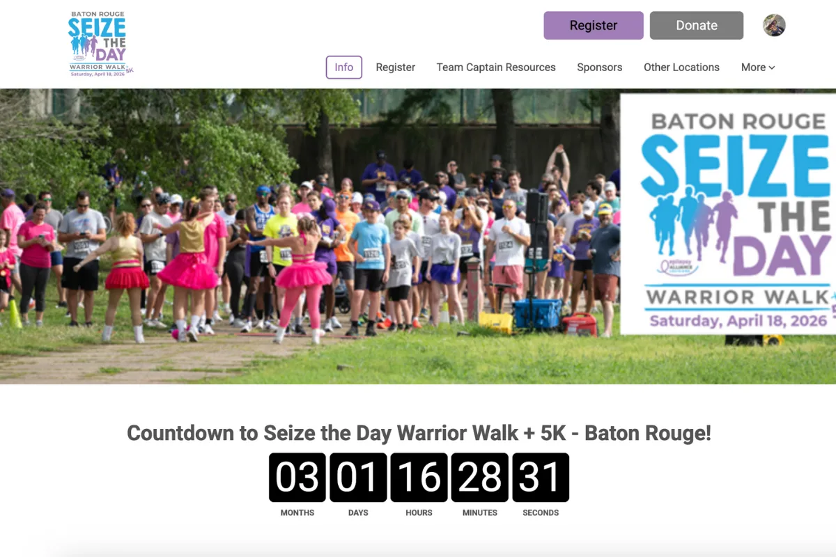 Top left: the Baton Rouge Seize the Day Warrior Walk + 5K logo.  Top navigation: Info (currently selected), Register, Team Captain Resources, Sponsors, Other Locations, and a More dropdown.
Top right also has Register and Donate buttons plus a small profile/avatar icon.  Hero image: a large crowd gathered at what looks like a race/walk start area, with an oversized event graphic/sign on the right.  Below the hero: a line that reads “Countdown to Seize the Day Warrior Walk + 5K - Baton Rouge!”  Under that: a countdown timer showing 03 months, 01 days, 16 hours, 28 minutes, 31 seconds.